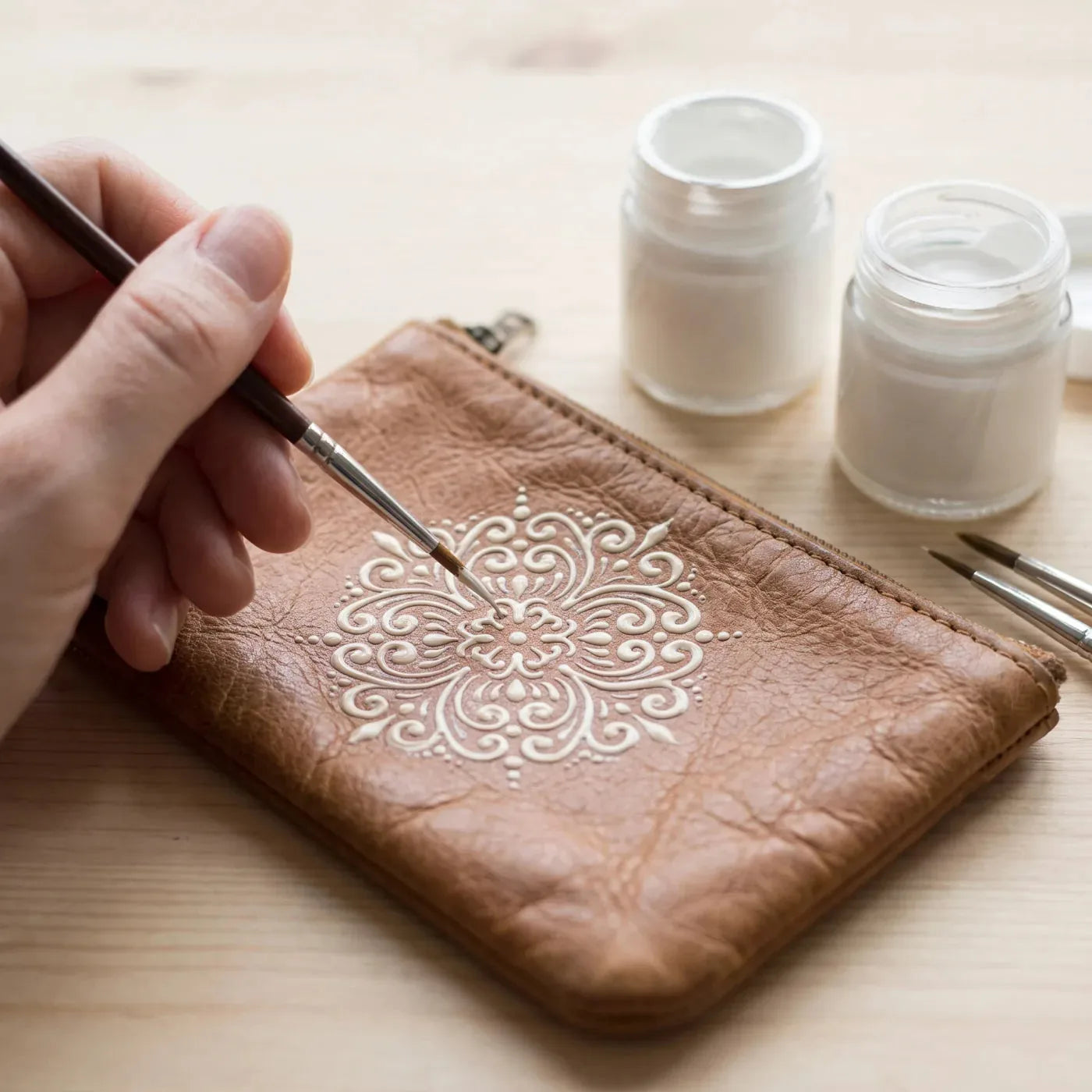 Ornament monocrom pictat cu vopsea pentru textile pe un portofel din piele