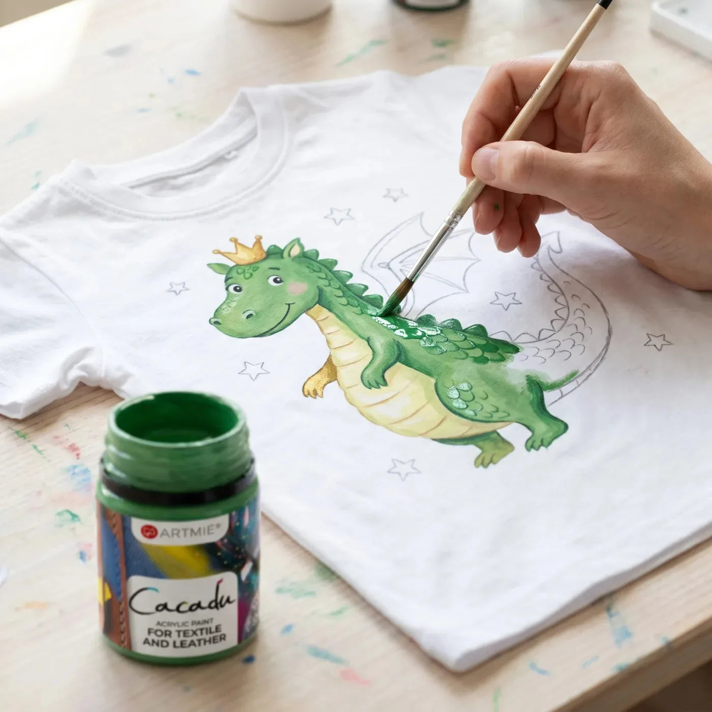 Prim-plan cu pictarea unui dragon verde cu vopsea Cacadu pe tricou